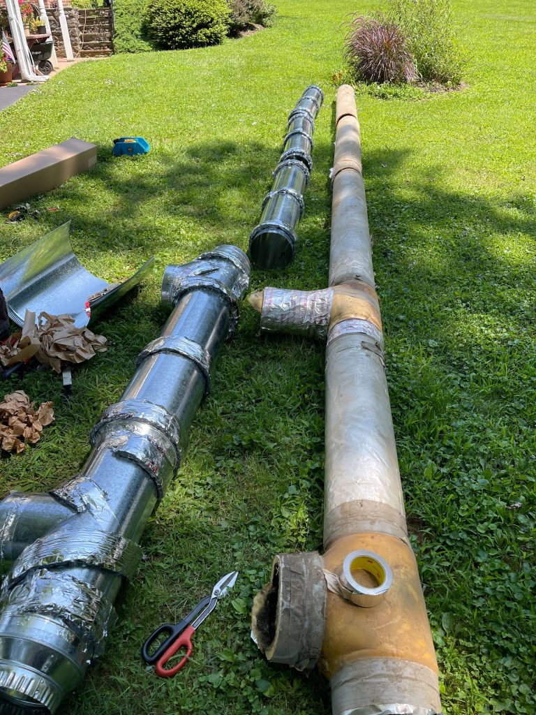 HVAC ductwork sits on the grass.